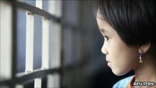 Burmese refugee Mang Thai Par, 7, looks out of a window at her family"s flat which they share with three other relatives in Kuala Lumpur June 24, 2011