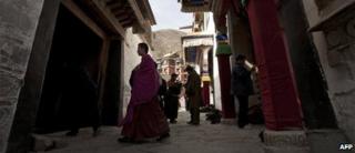 Tibetan monk walks past pilgrims at the Labrang monastery in Xiahe, Gansu province, file image