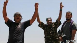 Libyan rebel fighters celebrate as they drive into the coastal city of Zawiya on Monday