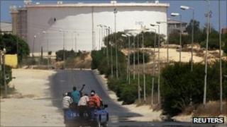 A truck carrying Libyan rebel fighters drives towards the oil refinery in Zawiya, Libya, 17 August 2011