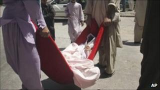 Afghans carry a victim of a roadside bomb in to a hospital in Herat - Aug. 18, 2011