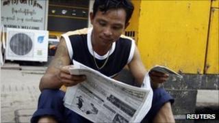 A man reads a newspaper in Rangoon on 17 August 2011