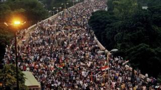 Supporters of Indian activist Anna Hazare march through a flyover in Delhi on Sunday 21 August 2011