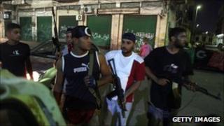 Libyan rebels patrol a street in Tripoli