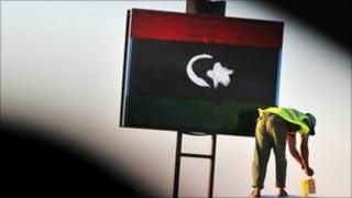 Man paints Libyan flag on a checkpoint