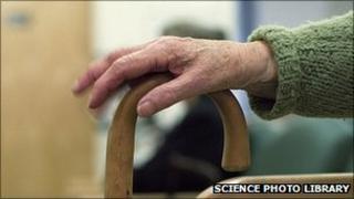 Old person's hand on walking stick