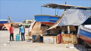 Migrant workers camp at a fishing port near Tripoli