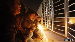 People light candles outside TVN national television in Santiago, 3 September 2011