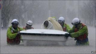 Rescue workers transport evacuees in a boat through floodwaters in Nagoya, Aichi prefecture, in central Japan