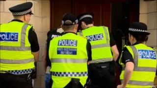 Officers in Pirniefield Bank in Edinburgh during dawn raids
