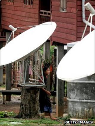 Girl stands by satellite dishes