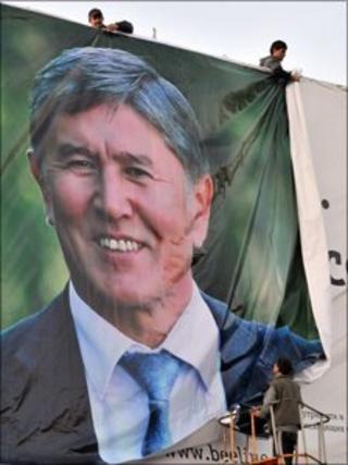 men hang Almazbek Atambayev campaign poster