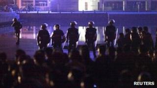 Riot police stand in front of residents at the entrance to the Zhili town government building after a protest in Huzhou city, Zhejiang province October 27