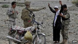 US soldier and Afghan soldier search a boy 5 October 2011