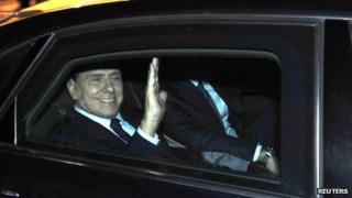 Prime Minister Silvio Berlusconi waves as he leaves his residence in Rome, 12 November 2011