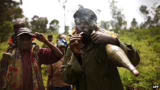 A Congolese rebel holding a rocket and lighting a cigarette (Archive shot)