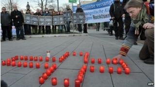 A man lights candles during a commemoration vigil for the victims of a murder series allegedly committed by a right-wing terror group, on November 28, 2011 in Erfurt, eastern Germany