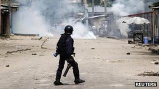 A riot policeman faces opposition protesters through a could of tear gas in Democratic Republic of Congo's capital Kinshasa on 10 December