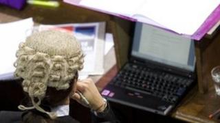 Barrister with laptop in courtroom