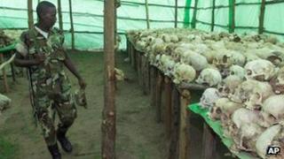 Rwandan soldier looks at the human skulls belonging to victims at the genocide memorial in Bisesero, Rwanda, November 2nd 1999