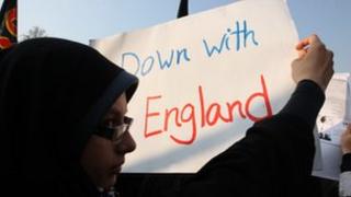 A protester holds a poster displaying the message 'Down with England' in Tehran
