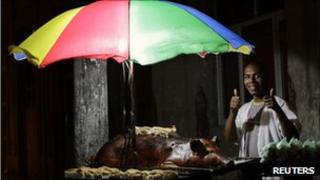 A Cuban selling meat on a street stall gives the thumbs -up