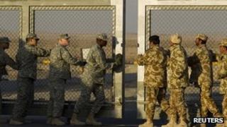 Kuwaiti and US soldiers close the border gate during the US military's withdrawal from Iraq 18 December 2011