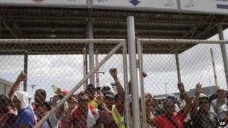 Labourers who were hired to work on the Panama Canal expansion project protest behind a fence in Cocoli on the outskirts of Panama City, 17 January 2012.