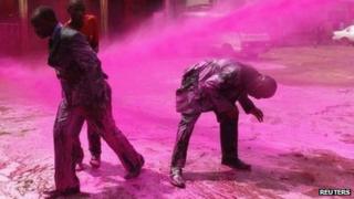 Anti-riot police use water cannons, with pink water, against opposition supporters in Uganda