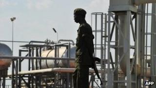 A Southern Sudanese soldier standing next to the infrastructure of an field processing facility in Unity State (file picture)