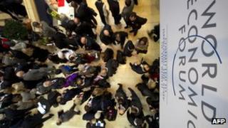 People walking under a World Economic Forum sign