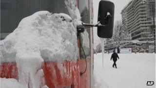 A Bosnian man walks near a frozen tram in the Bosnian capital of Sarajevo, on February 4