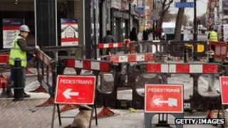 workmen digging up a pavement