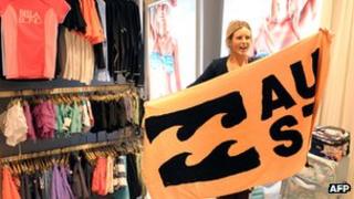 A consumer holds a beach towel with the Billabong wave logo