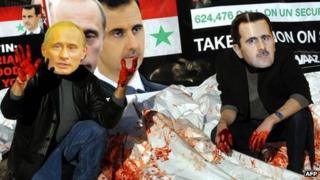 Avaaz activists wearing masks of Russian PM Vladimir Putin and Syrian President Bashar al-Assad dump bloodied body bags outside the UN's headquarters in New York (24 January 2012)