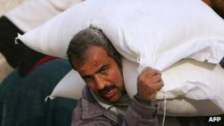 A Palestinian collects food aid. File photo