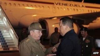 Hugo Chavez (r) is greeted by Cuban President Raul Castro on arrival in Havana
