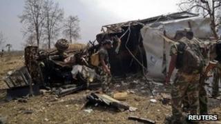Policemen stand near the wreckage of a police vehicle after a landmine explosion in Gadchiroli, about 1000 km (600 miles) east of Mumbai March 27, 2012.