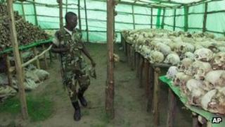 A Rwandan soldier looks at the hundreds of human skulls and remains of genocide victims at the genocide memorial in Bisesero, Rwanda