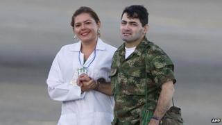 Luis Afonso Beltran (right) is helped off the helicopter after landing in Villavicencio