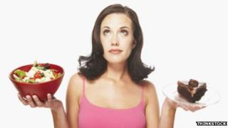 Woman holding salad and cake