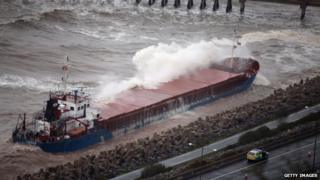 Cargo ship hit a rock in rough seas off the north Wales coast.