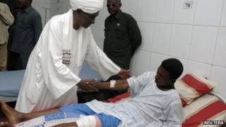 Sudan's First Vice President Ali Osman Taha visits a wounded soldier in Khartoum, 13 April