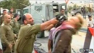 A still from video footage showing the demonstrator being hit in the face with a gun