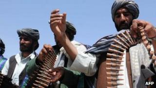 Former Taliban fighters display their weapons as they join Afghan government forces during a ceremony in Herat province on April 26, 2012.