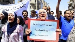 A woman holds up a banner saying "No to an expired government" at a protest demanding political reforms in Amman (4 May 2012)