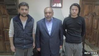 Turkish journalists Adem Ozkose (L) and cameraman Hamit Coskun (R) pose with the President of the Foundation for Human Rights and Freedoms and Humanitarian Relief Fehmi Bulent Yildirim in Damascus, in this handout picture released by IHH on May 7, 2012