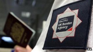 UK Border Agency officer holding passport