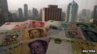 China yuan bank notes and the Shanghai skyline