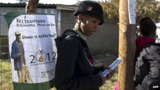 A woman stands near an election poster in Maseru on May 24, 2012 two days ahead of the southern African state of Lesotho"s parliamentary elections.